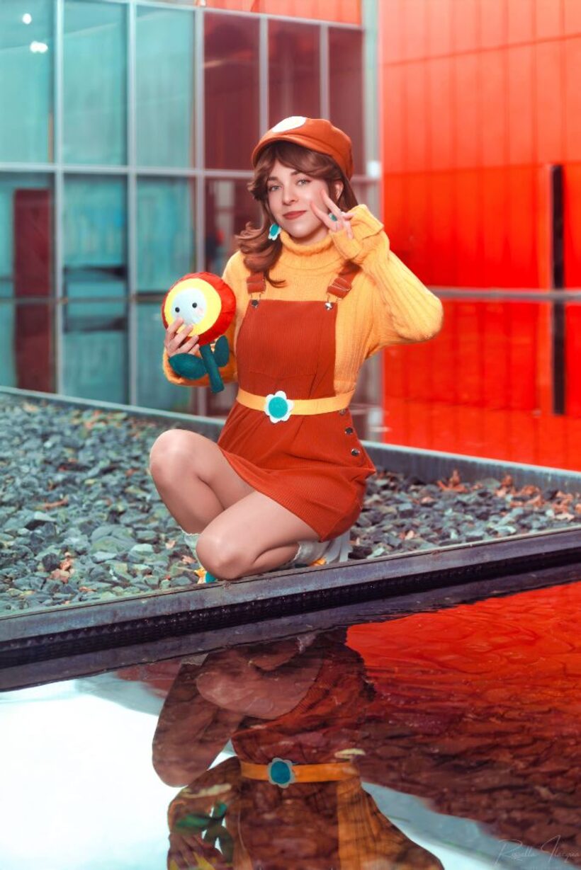 Cosplayer in costume arancione accovacciata a bordo vasca